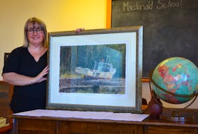 Macdonald Museum director Janice Slauenwhite holds up one of the two Tom Forrestall prints donated by the artist to the museum’s gala dinner, auction, and dance fundraiser Nov. 2 at the NSCC in Middleton. One will be the door prize for the evening.