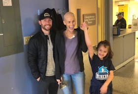 Judy DesRoches celebrates her last chemotherapy treatment by ringing the bell with her husband, Marc, and daughter, Lydia.