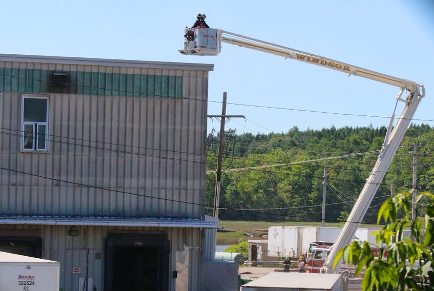 Aerial trucks were positioned around the backside of CKF’s main industrial building as firefighters worked to contain and extinguish a fire at the paper product plant June 17.