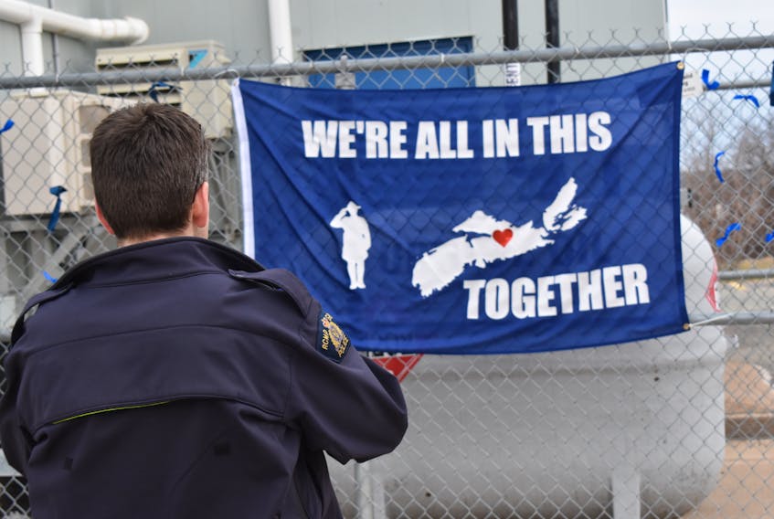 Const. Terry Garvin snaps a photo of a flag a local resident made for the Windsor West Hants RCMP detachment to show support following the devastating mass shooting in Nova Scotia.