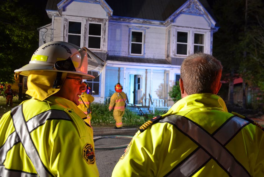 Middleton firefighters received a 10 p.m. call to 12 School Street Aug. 19 where a vacant house was on fire. Deputy Fire Chief Jody Spidle, left, was first on scene and described lots of smoke. Chief Mike Toole, right, ran the scene from the front of the house and later donned gear to inspect the inside.