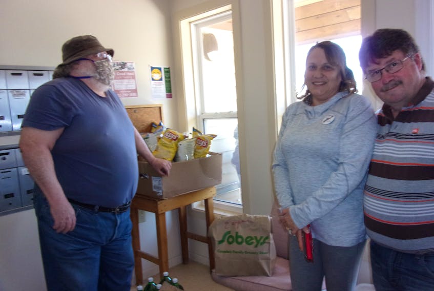J.B. North resident Howard Pulsifer happily welcomes Caremonger support group co-ordinator Leslie Porter and her husband, Hants West MLA Chuck Porter, as they arrive with groceries and treats for the seniors staying home in isolation as a precaution due to the COVID-19 virus. Annie Bird photo