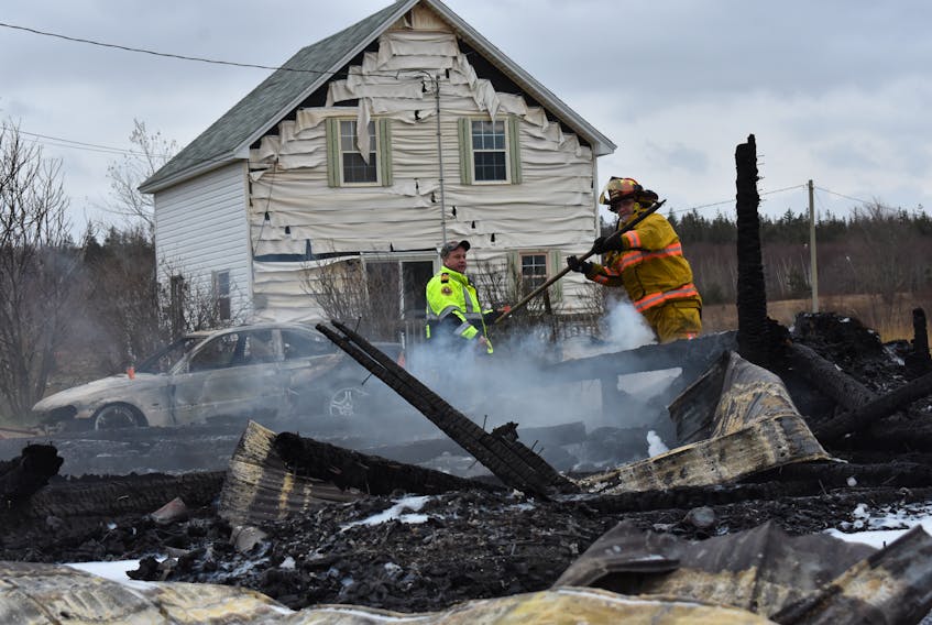 Chief Mike Toole and Capt. Hilliard Ewing of the Middleton Fire Department survey the charred remnants of a barn in Port George for hotspots following an early-morning fire on Douglas Road.