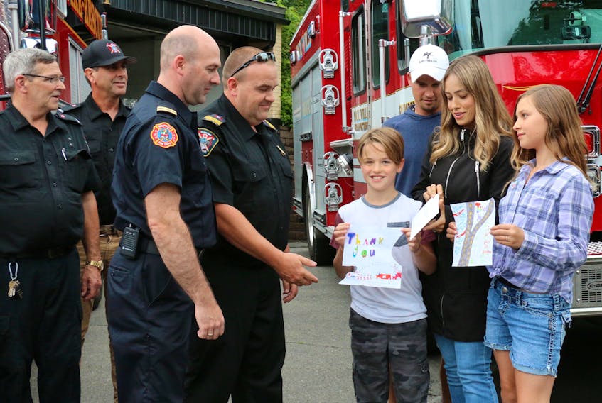 The Yeaton family, Tyler and Chelsea Yeaton, with their children Ryder and Oakley, stopped by the Hantsport Fire Department July 23 to present them with a token of appreciation for the role Hantsport and Wolfville firefighters played in rescuing Chelsea and Oakley following an accident in May. Pictured receiving the items are Wolfville Capt. Ken White and Hantsport Deputy Fire Chief Paul Maynard.