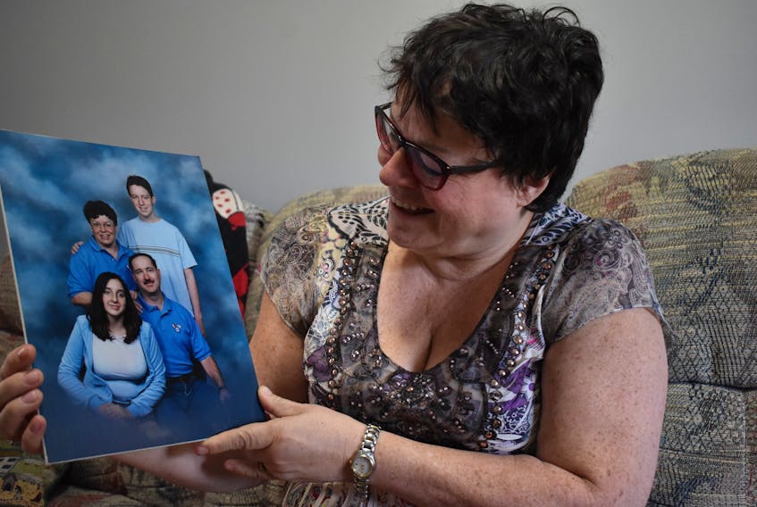 Trish Gallant of Kingston admires a family photo of herself, her husband Louis and their children, Daniel and Laura.