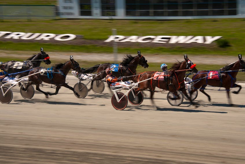 Horses cross the finish line during a race at the Truro Raceway in Truro, Sunday, July 14, 2013. (ADRIEN VECZAN/Staff