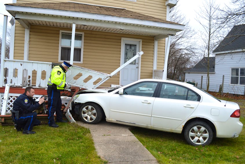 Const. Calvin Thomas (left) and Const. Dave Kelly, of the Cape Breton Regional Police Service, investigate at the scene of a single vehicle accident Wednesday, after a vehicle crashed into the steps of a two-unit structure on Union Street in Glace Bay. Police say the accident was the result of a new driver simply making a driving error.