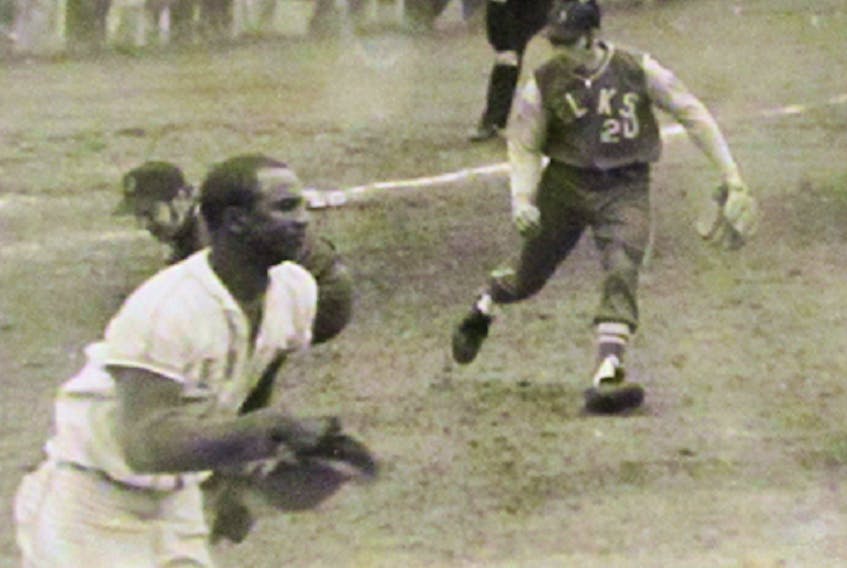 The Elks’ Stirling Delaney, No. 20, charges in from third base to field the ball as Halifax Keiths’ Cecil Jackson races toward first base. The 1969 playoff game in Brookfield attracted more than 1,200 fans.