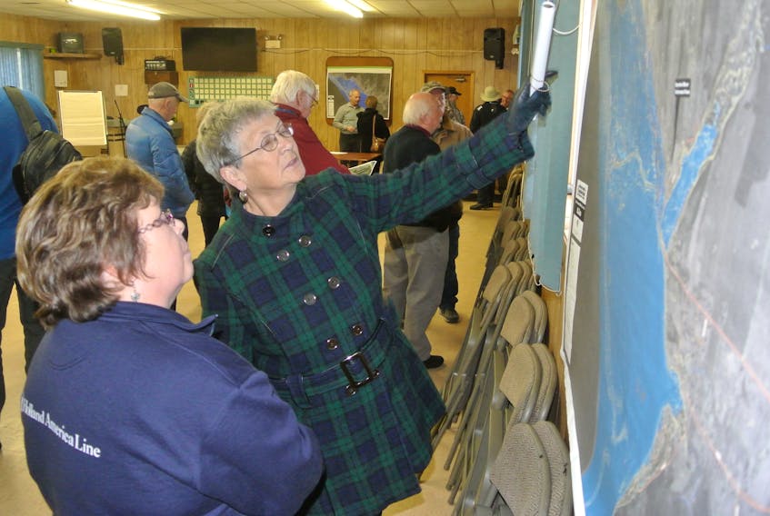 (From left) Cheryl Phinney and Marilyn Welton look over a map of the dike protecting Advocate Harbour and how rising sea levels could compromise the structure by 2100.