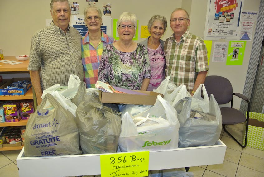 Doris Walton (centre) is with After the School Bell Food Program volunteers Dave and Rachelle Dowe, Marie Marshall and Steven Ripley as the final 25 bags of food were prepared to be sent to West Highland Elementary on June 21. The program provided 856 bags during the 2018-19 school year and will expand next year to support at least 10 bags per week at Spring Street Academy.