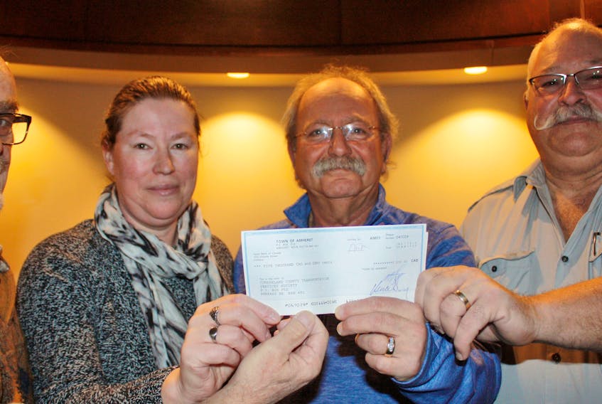 Amherst Mayor David Kogon presents Cumberland County Transportation Service Society members Peter Lewis, Helen Sims and Bruce Cuco a $5,000 cheque, which the society will use to help it purchase a new bus.