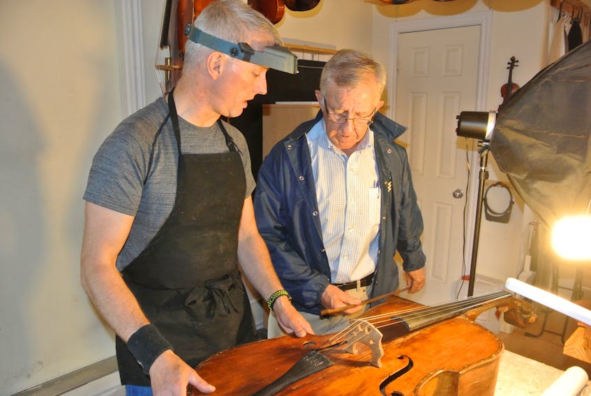 Ray Coulson (right) , curator of the North Nova Scotia Highlanders Regimental Museum, looks over a 100-year-old cello that Charles Long of Atelier VioLong of Dieppe, N.B. restored. The cello, made by an intern at the First World War Amherst internment camp, will be played by a member of the German Luftwaffe Band during a ceremony in Amherst July 2 to commemorate the 100th anniversary of the camp’s closing.