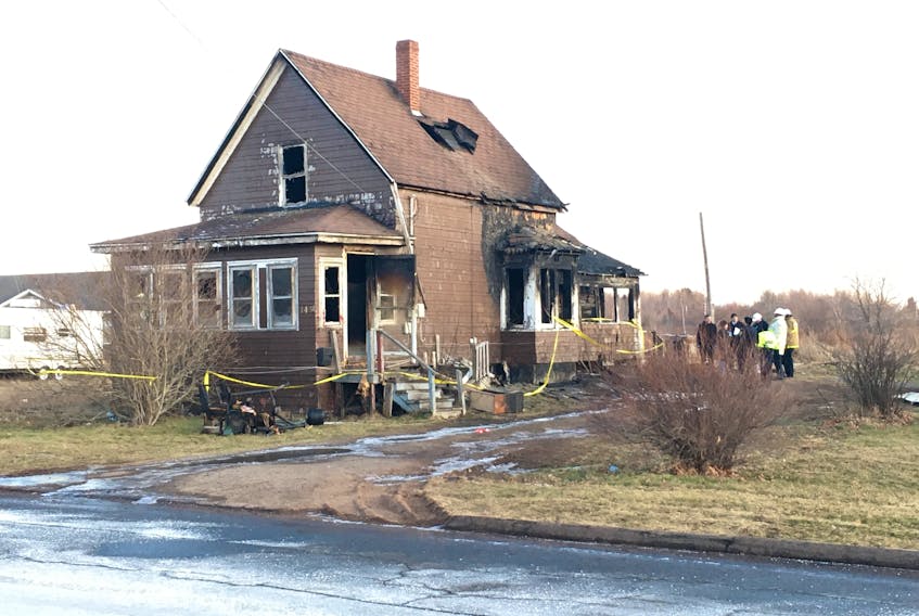 Amherst Police and fire officials stand outside the East Pleasant Street home that was the scene of a fatal fire early on Dec. 21. Two women, charged with various offences following the fire, made a brief appearance in provincial court in Amherst on Monday and will remain in custody until Jan. 2 when they return for a bail hearing.