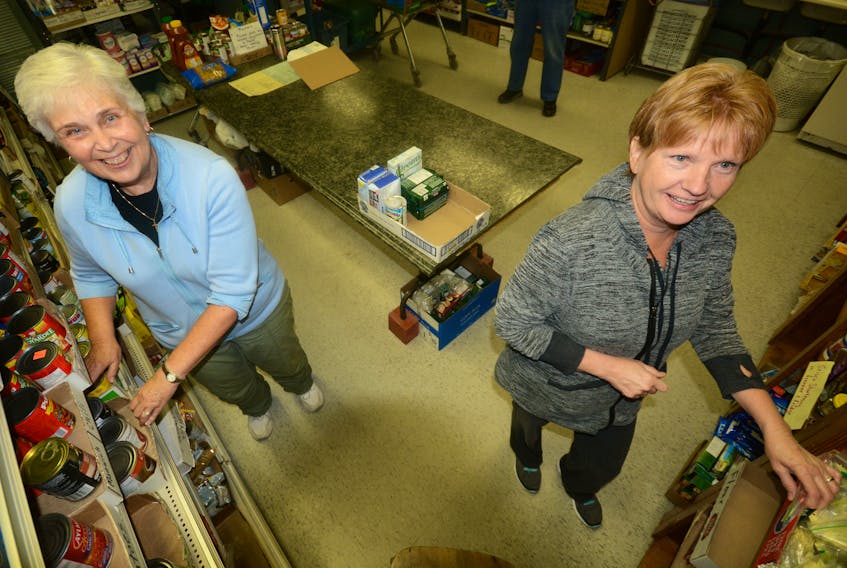 Charlotte Ross and Christine Davis were recently restocking shelves in preparation for the next rush of people at the Amherst Food Bank. The shelves are left almost bare after people collect food Monday, Wednesday, and Friday afternoon. Ross is chairperson, and Davis the food facilitator, at the Amherst Food Assistance Network.