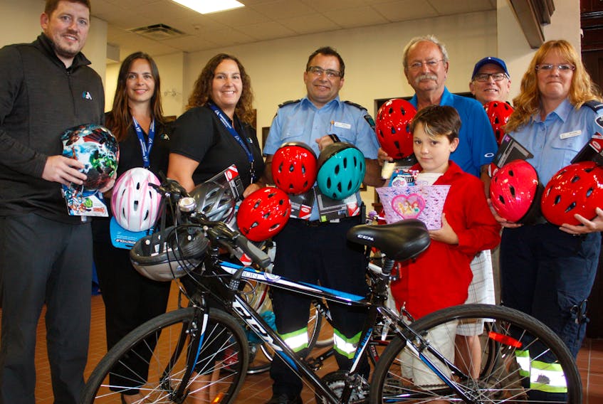 Mayor David Kogon, Oulton College students Rodney Howse, Brenda Hicks and town recreation staff show some of the bicycle helmets the primary paramedic class at the college donated to the town. (From left) Corey Crocker, Jennifer Bickerton, Tamara Porter are joined by Howse, the mayor, George Drew, Bill Schurman and Hicks during the presentation.