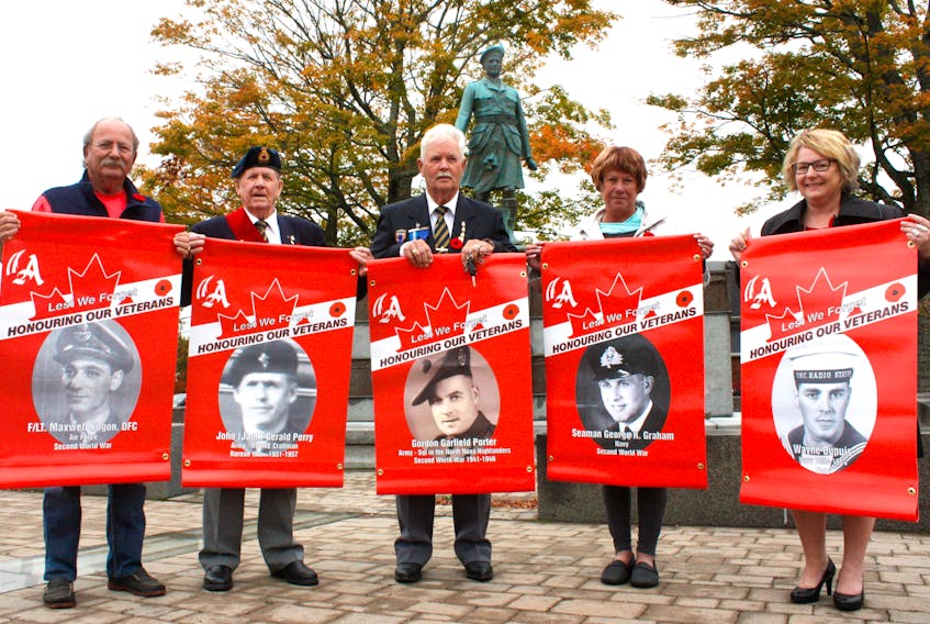 Amherst and Branch 10 of the Royal Canadian Legion are hanging banners bearing photos of 34 veterans of Canada’s wars and peacekeeping missions. (From left) Mayor David Kogon, legion sergeant-at-arms Jack Perry, president Roy Porter, Debbie Kogon and Deputy Mayor Sheila Christie show some of the banners than will be hung in the downtown area.