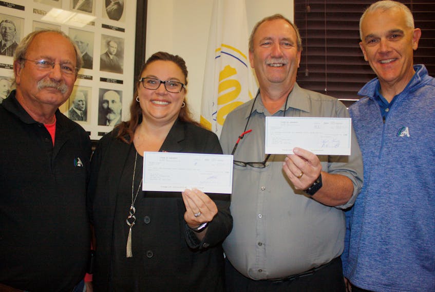 Amherst Mayor David Kogon (left) and CAO Greg Herrett (right) present Cumberland YMCA CEO Trina Clarke and YMCA board president with cheques amounting to $60,000 – the first installment of a new multi-year agreement between the town and they YMCA.