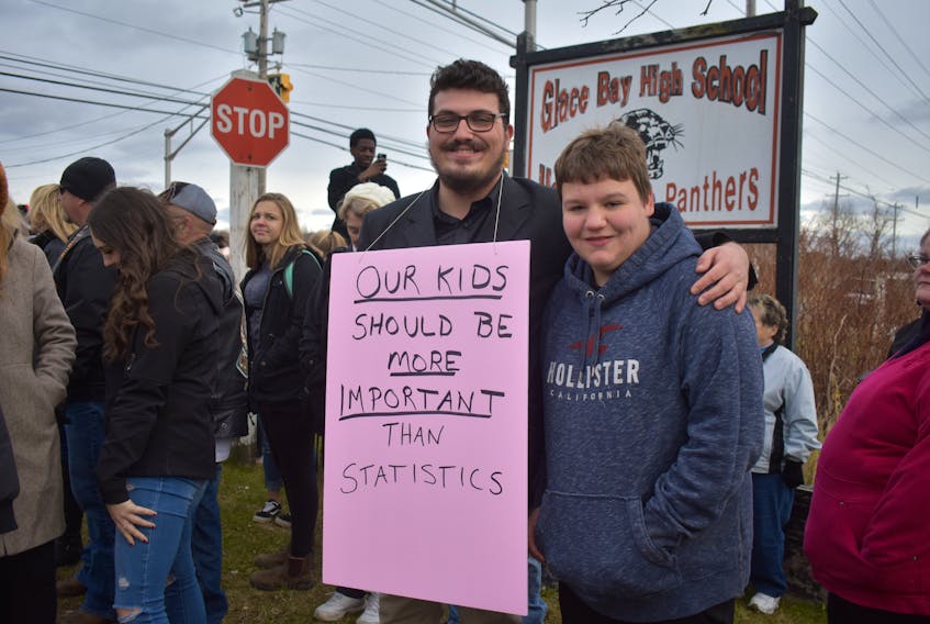 Brett Corbett, 14, right, stands with his close friend, Brandon Jolie, who helped organize the rally. Jolie said he considers Corbett a brother and hopes students will learn this behaviour isn’t acceptable.