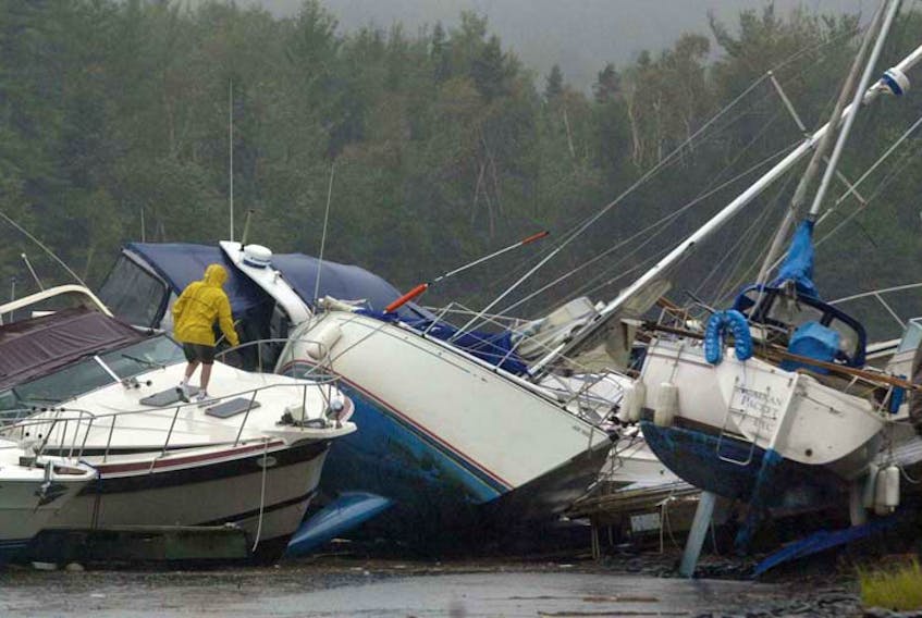 A boater inspects thrown sailboats at the Dartmouth Yacht Club, following hurricane Juan's ravages on Monday, Sept. 29, 2003.