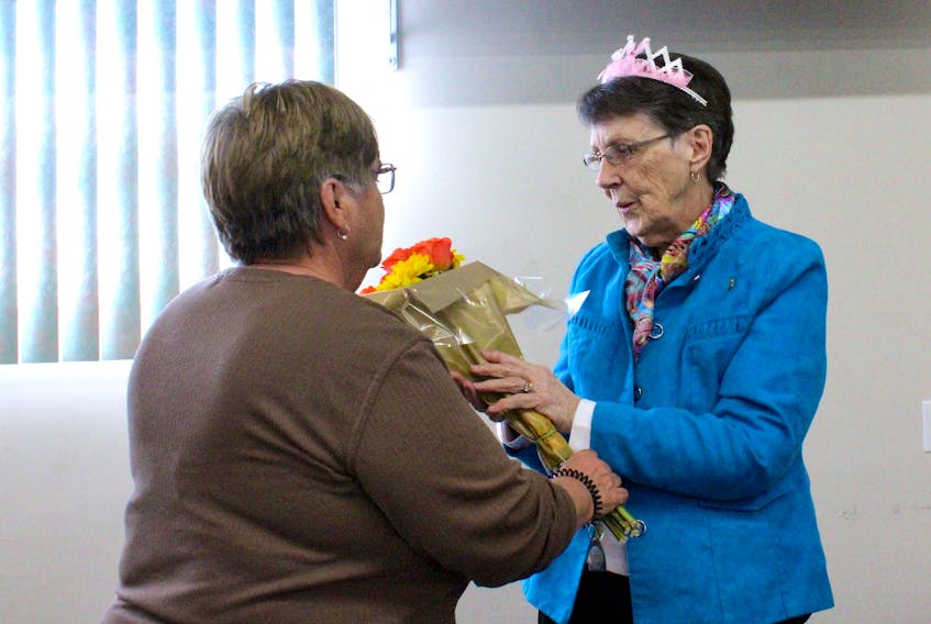 Audrey Hicks is presented with flowers on Friday from Sackville’s program and events coordinator Deanna Cadman after being named this year’s Queen of Winterfest