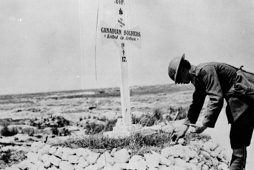 
A First World War soldier places stones on a Canadian grave near Vimy, France in this June 1917 archive photo. National Archives of Canada/File
