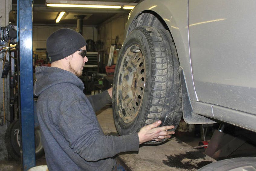 Bret Keohan of Canning Auto Service puts a snow tire on a car Wednesday afternoon. The cold weather seems to be prompting people to get their snow tires on even before the first snow falls.
