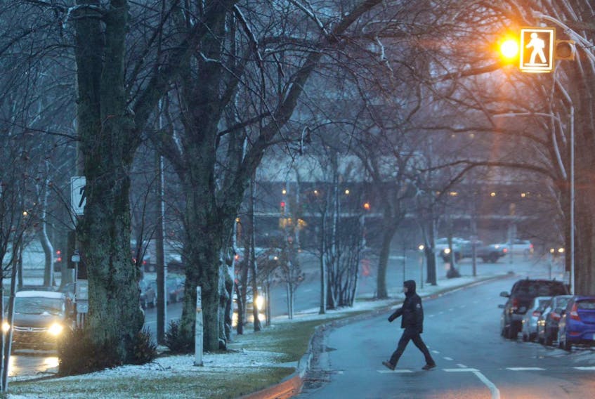 
A pedestrian walks across a crosswalk on Cogswell Street in Halifax on Thursday morning. Nova Scotia is in the grips of another late fall storm. Halifax hasn’t faired too badly as snow was turning to rain in the early morning, but more northern areas of the province are seeing mostly snow. - Eric Wynne
