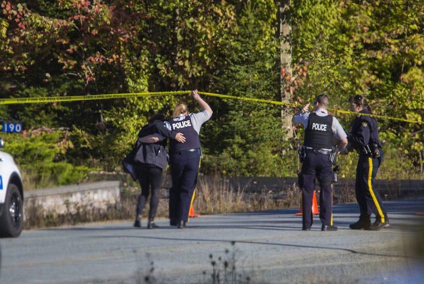 
An RCMP officer escorts a family member to the scene of a crash in Hammonds Plains on Oct. 13, 2017, that killed a 17-year-old boy. - Tim Krochak
