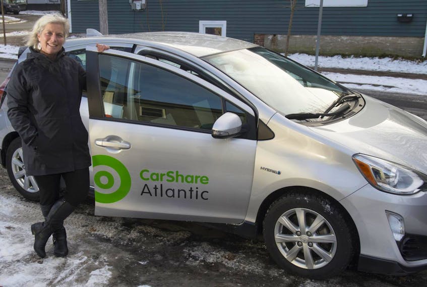 CarShare Atlantic CEO Pam Cooley poses for a photo with one of the company’s vehicles. Cooley has sold the company and is leaving as CEO in February.