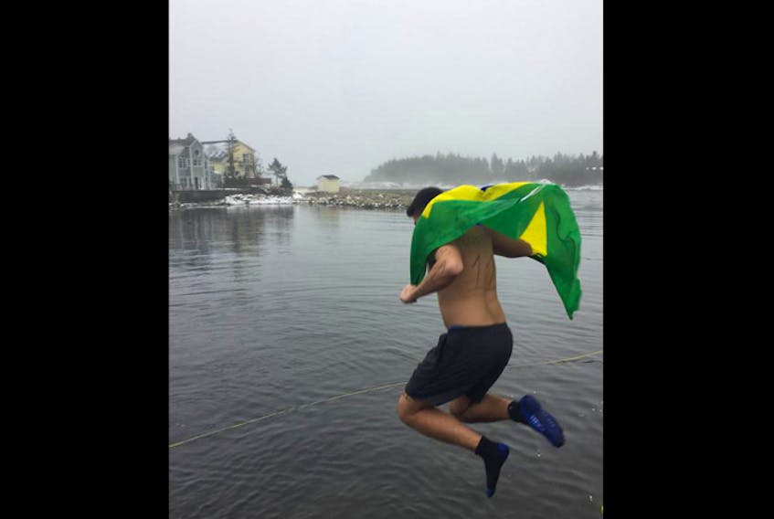 
Leonardo Souza Guinsburg flies the Brazilian flag as he steps off the wharf in Herring Cove on Tuesday.
