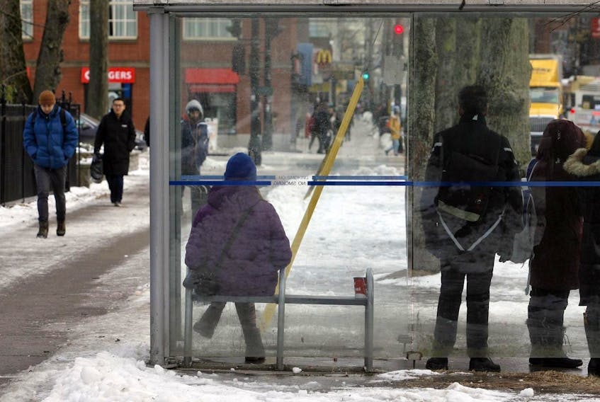 
People wait in a bus shelter next to the Public Gardens on Spring Garden Road on Thursday.. ERIC WYNNE/Chronicle Herald

