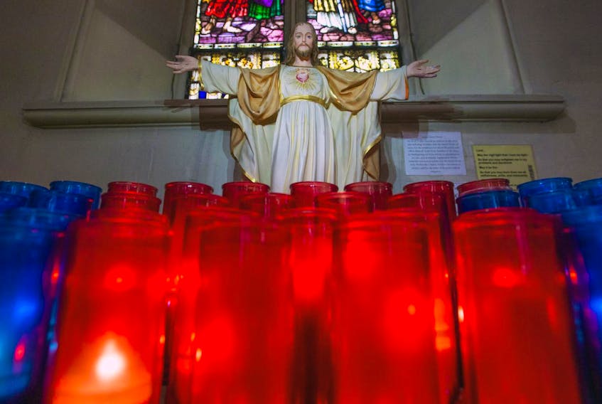Vigil candles flicker in front of small statue of Jesus inside St. Mary’s Basilica.