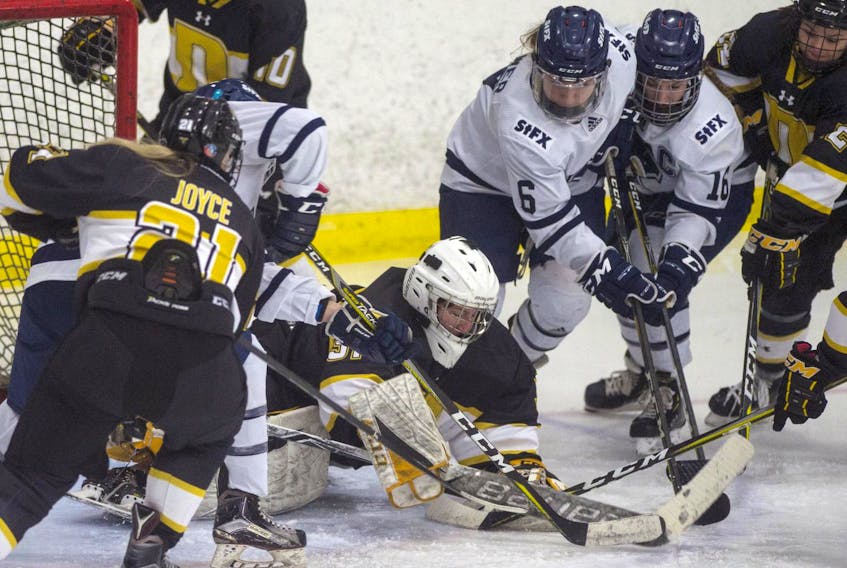 
Dalhousie Tigers goalie Fabiana Petricca jumps on the puck as she is surrounded by St. Francis Xavier X-Women players during Wednesday night’s AUS women’s hockey game at the Civic Centre. - Ryan Taplin
