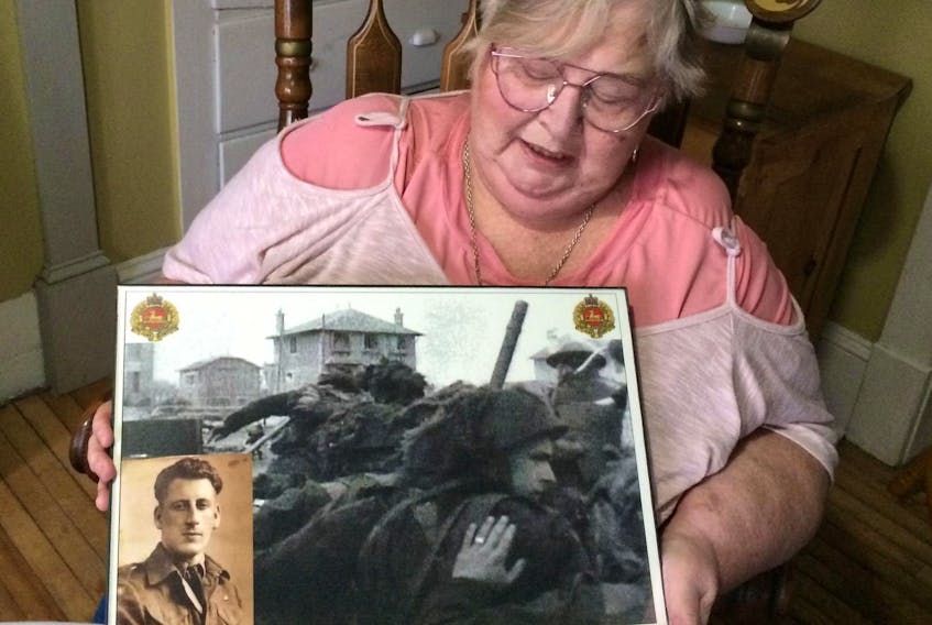 
Karen McLeod with the iconic photograph of her father George Baker during the D-Day landing at Juno Beach, featured on a new Canadian commemorative coin. - John DeMont

