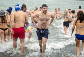 People head back to the shore at Black Rock Beach in Halifax’s Point Pleasant Park on Wednesday after a polar dip in support of Phoenix Youth mental health programs.