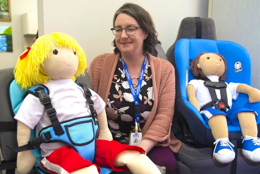 
Katherine Hutka, a health promotions specialist, poses for a photo with a car seat that was sold online through Walmart. The seat on the left does not meet legal safety requirements On the right is a seat that meets safety requirements. - Ryan Taplin

