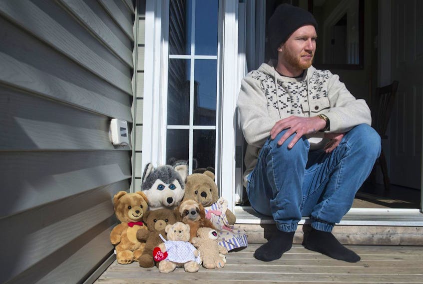 
Brandon Christian sits outside his house on Alabaster Way with seven stuffed animals in memory of the seven children who died in Tuesday morning’s fire in Spryfield. Christian lives next to Quartz Road and witnessed the fire that destroyed the house. - Ryan Taplin
