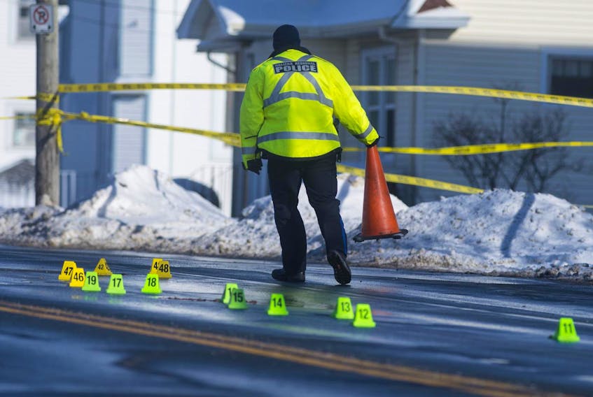 
A police officer clears a traffic cone at the scene of a fatal pedestrian collision Friday morning. A 57-year-old man was killed in the collision at about 5:50 a.m. on Pleasant Street. - Ryan Taplin
