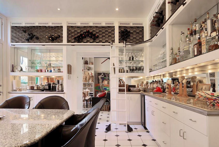 
Built-in wine rack, shelving, ladder, mirrored walls and art deco flooring are features of maximalism style in the kitchen. An additional layer of décor, displaying statues, glassware and liquors all reflect a love of fine spirits and traveling. - Up Photography 
