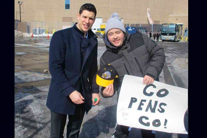 
Dylan Atack of Hamilton meets with Sidney Crosby last Friday outside the Buffalo arena. Crosby signed his poster and Atack, who works for the Hamilton Tiger-Cats football team, gave him a Ti-Cats hat. - Contributed
