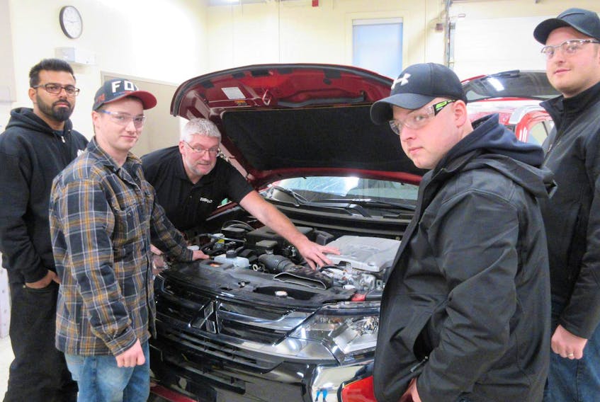 
Mitsubishi Motors Canada donated a damaged Outlander PHEV to the Akerley Campus of Nova Scotia Community College for use in its automotive power programs. Pictured, from left, are: Level 1 Apprenticeship students Arjun and Morgan, instructor Barry Parsons, and Level 1 Apprenticeship students Jonathan and Adam. - Skana Gee
