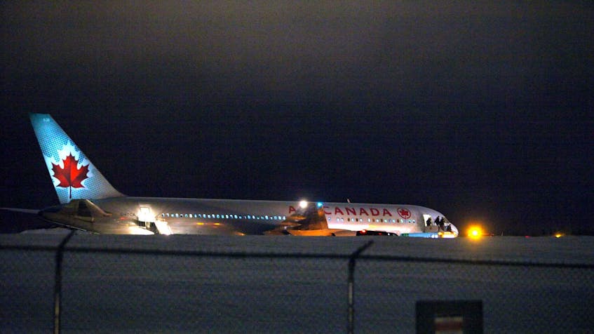 
Passengers and crew disembark from an Air Canada airplane stuck halfway down the main runway at Halifax Stanfield International Airport on Monday night. - Eric Wynne

