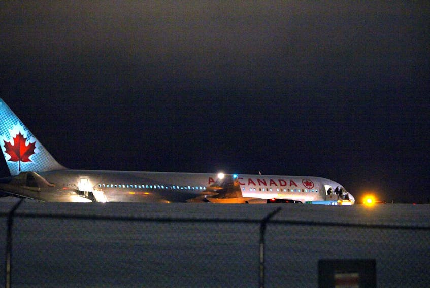 
Passengers and crew disembark from an Air Canada airplane stuck halfway down the main runway at Halifax Stanfield International Airport on Monday night. - Eric Wynne
