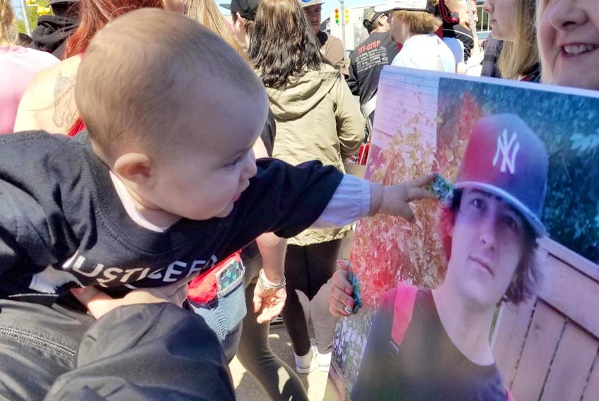 
Joneil Hanna’s infant daughter, Harper, is shown reaching for her late father’s portrait during a Justice for Joneil rally at the Cape Breton Regional Police detachment in Sydney Mines on June 16, 2018. - Denise Axworthy
