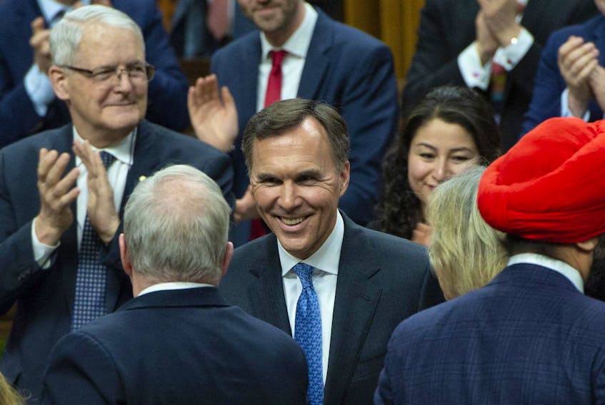 Finance Minister Bill Morneau is congratulated by colleagues following the delivery of the federal budget in the House of Commons in Ottawa on Tuesday.
