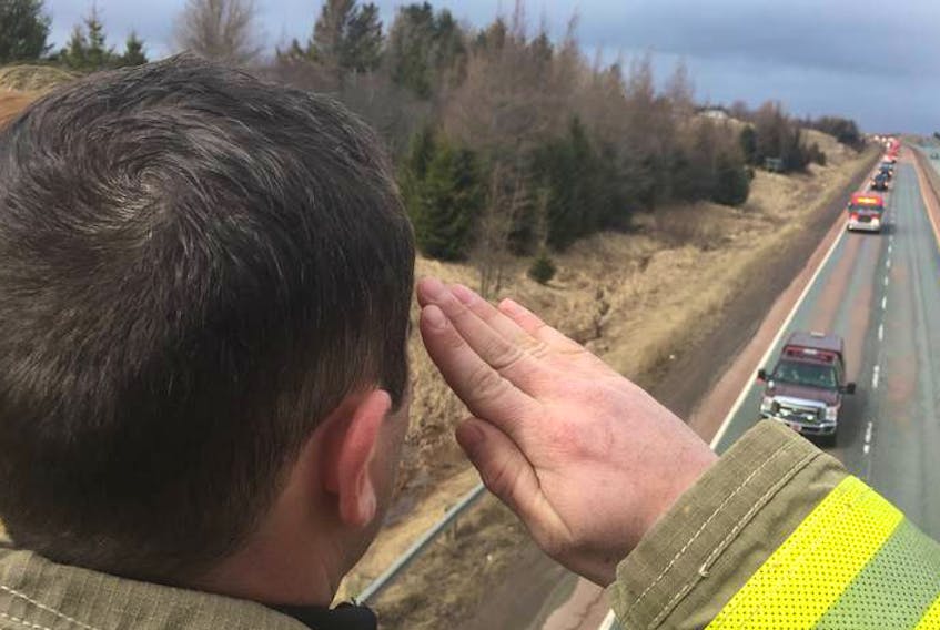 
Firefighter Jason McRae salutes the convoy bearing Skyler Blackie’s remains as it passes under the Onslow Road bridge on its way back to Truro on Saturday. 
FRAM DIMSHAW TRURO NEWS



