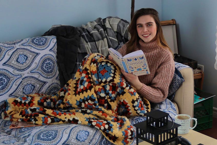 
Find the corner of a room where you can curl up with a blanket, good book and cup of tea to help get your Hygge on, like Millicent McKay is doing here. - Submitted
