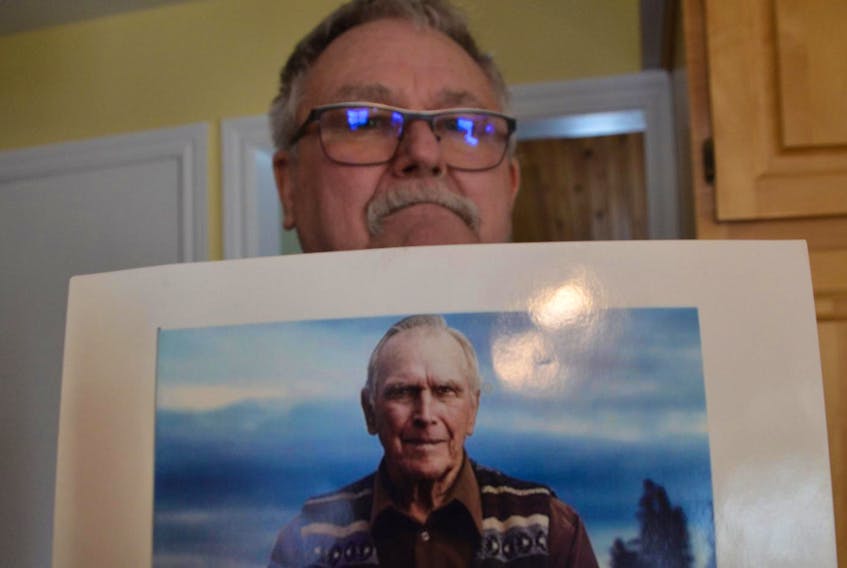 
David Blankenship holds a photo of his father, famed Oak Island treasure hunter Daniel Blankenship. 
