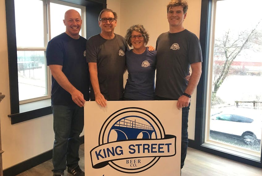 
Saltbox Brewing Company partners Andrew Tanner (left), George Anderson, Jane McLoughlin and Patrick Jardine (right) showcase the logo of their latest project, the King Street Beer Company. The new location is expected to open May 3. 
