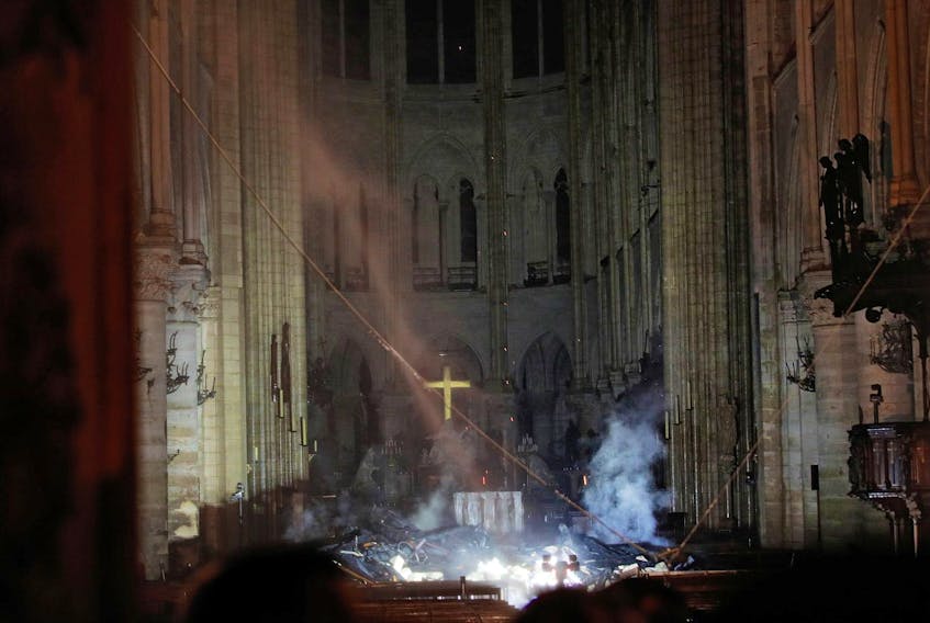 
Smoke rises around the altar in front of the cross inside the Notre Dame Cathedral as a fire continued to burn in Paris on Tuesday. - Reuters

